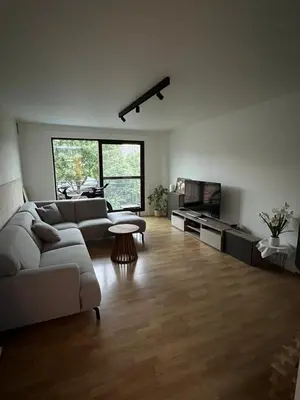 a living room with a couch and a tv at Toverpoort - Seperate room in shared apartment in Ghent