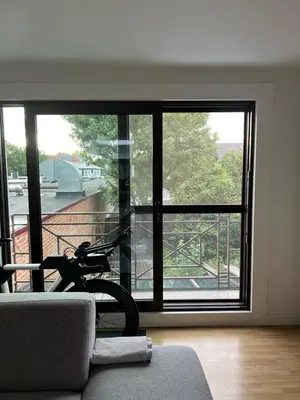 a living room with a bike parked in front of a window at Toverpoort - Seperate room in shared apartment in Ghent