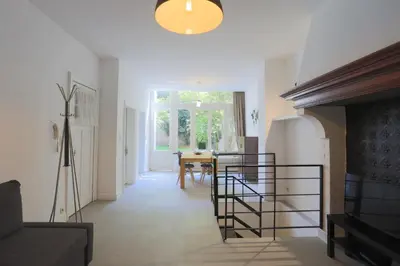 a living room with a couch and a dining room table at Belliard flat in Brussels