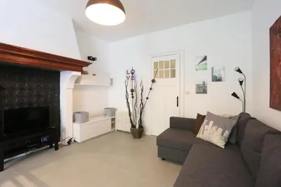 a living room with a couch and a television at Belliard flat in Brussels