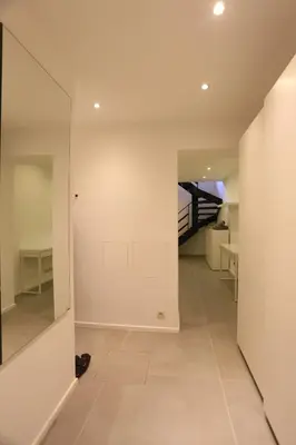 a hallway with white walls and a staircase at Belliard flat in Brussels