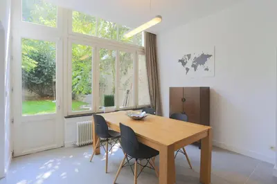 a dining room with a wooden table and chairs at Belliard flat in Brussels