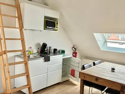 a kitchen with a ladder and a sink and a table at Dock Loft in Ghent