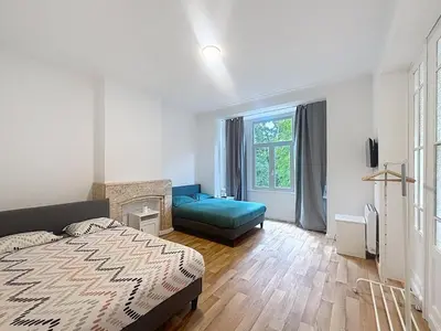 a bedroom with a bed and a couch and a window at Basilique Brussels 2 in Brussels