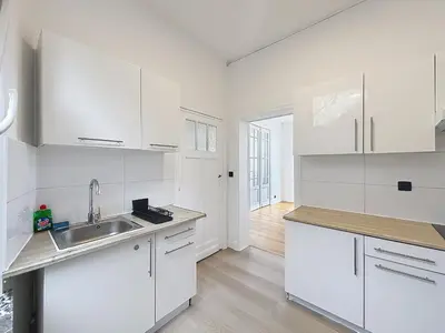 a white kitchen with white cabinets and a sink at Elisabeth Brussels 3 in Brussels