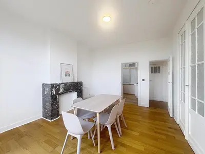a dining room with a table and white chairs at City Brussels 5 in Brussels