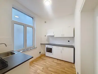 a kitchen with white cabinets and a large window at Leopold Brussels 6 in Brussels