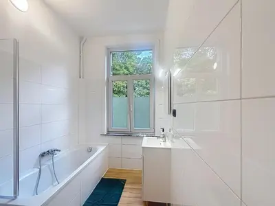 a bathroom with a tub and a sink and a window at Leopold Brussels 6 in Brussels