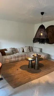 a living room with a couch and two tables at Cozy apartment with garden in Ghent