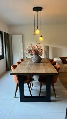 a dining room table with a vase of flowers on it at Cozy apartment with garden in Ghent