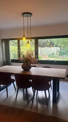 a large dining room table with chairs and a large window at Cozy apartment with garden in Ghent