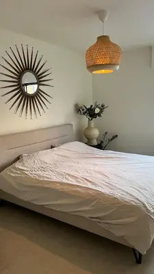 a bedroom with a bed with a mirror on the wall at Cozy apartment with garden in Ghent