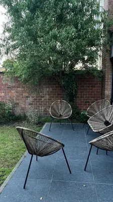 three benches sitting on a sidewalk next to a brick wall at Cozy apartment with garden in Ghent