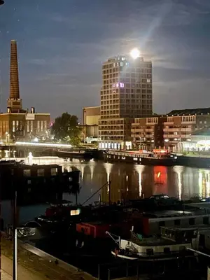 a city at night with boats in a harbor at DoK9 in Ghent