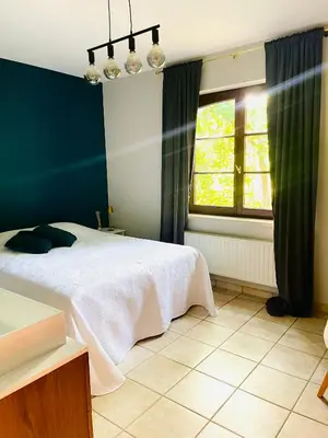 a bedroom with a white bed and a window at Zenitude in Tremelo