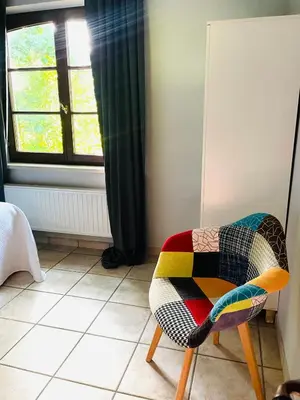 a colorful chair in a room with a window at Zenitude in Tremelo