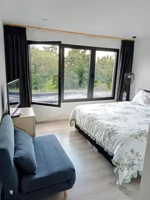 a bedroom with a bed and a couch and windows at Tomorrowlandhome Boom in Boom