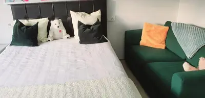a bed with pillows and a teddy bear sitting on it at Tomorrowlandhome Boom in Boom