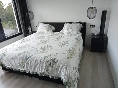 a bedroom with a bed with a white comforter at Tomorrowlandhome Boom in Boom