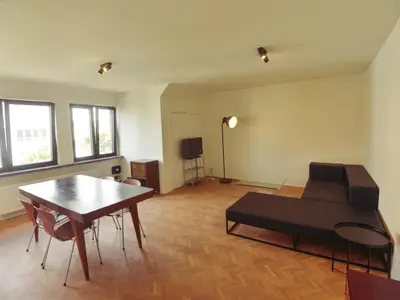 a living room with a couch and a table at Top floor apartment at Saint Peters Station in Ghent