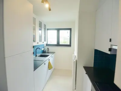 a white kitchen with a sink and a window at Top floor apartment at Saint Peters Station in Ghent