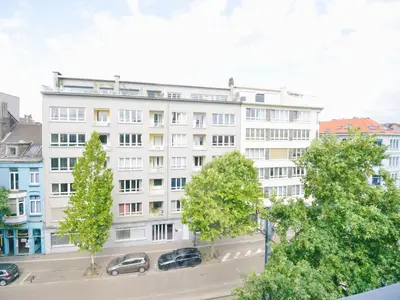 a white building with cars parked in front of it at Top floor apartment at Saint Peters Station in Ghent
