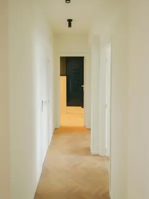 an empty hallway with white walls and a door at Top floor apartment at Saint Peters Station in Ghent