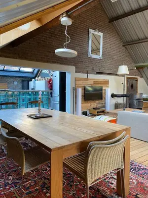 a wooden table and chairs in a living room at The Urban Loft in Brussels West in Brussels