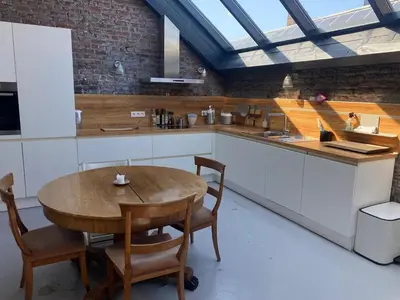 a kitchen with a wooden table and a table and chairs at The Urban Loft in Brussels West in Brussels