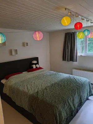 a bedroom with a bed with colorful lights on the ceiling at Ontferming RwinteR in Mol