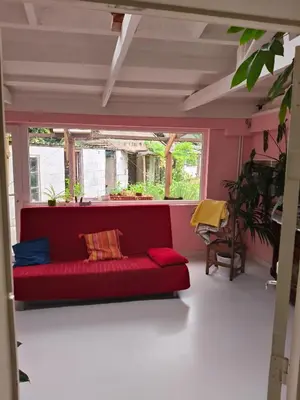a red couch in a room with a window at Ontferming RwinteR in Mol