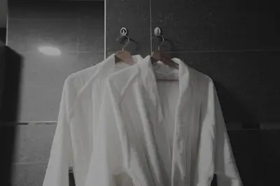 a white robe on a hanger in a bathroom at Chic Loft Facing Neo-Gothic Church in Ghent