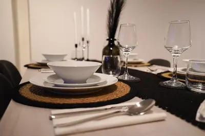 a table with plates and bowls and wine glasses at Chic Loft Facing Neo-Gothic Church in Ghent