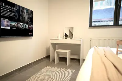 a bedroom with a desk and a tv on the wall at Chic Loft Facing Neo-Gothic Church in Ghent