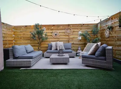 a patio with two couches and a table on the grass at Chic Loft Facing Neo-Gothic Church in Ghent