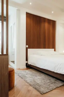 a bedroom with a large bed with a wooden headboard at Il Ponte Private Room with Hotel-Style Comfort in Ghent