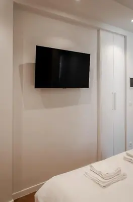 a flat screen tv hanging on a white wall at Il Ponte Private Room with Hotel-Style Comfort in Ghent