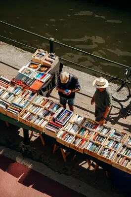 two people standing around a table with books on it at Il Ponte Private Room with Hotel-Style Comfort in Ghent