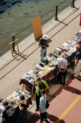 a group of people standing around tables with books at Il Ponte Private Room with Hotel-Style Comfort in Ghent
