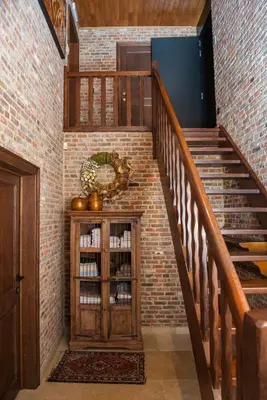 a staircase with a wooden cabinet in a brick wall at B&B Tspijker in Mol