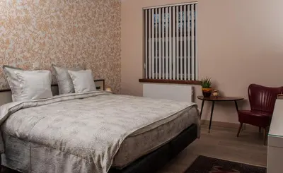a bedroom with a bed and a table and a window at B&B Tspijker in Mol