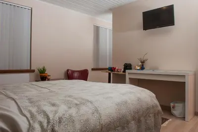 a bedroom with a bed and a desk and a television at B&B Tspijker in Mol