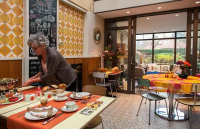 a woman preparing food at a table in a restaurant at B&B Tspijker in Mol