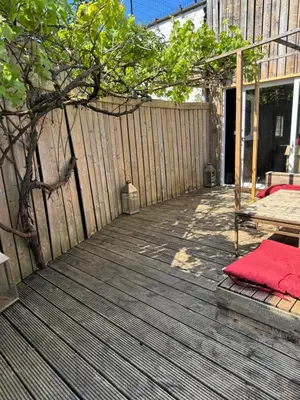 a wooden deck with a fence and a red blanket at Loft Cosy avec billard et à 10 minutes de l'aéroport de Zaventem in Machelen