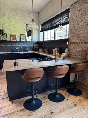 a kitchen with a counter with two bar stools at Loft Cosy avec billard et à 10 minutes de l'aéroport de Zaventem in Machelen