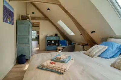 a bedroom with a bed with towels on it at B&B 't Kruidenhof in Assenede