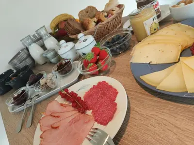 a table topped with plates of cheese and meats at B&B 't Kruidenhof in Assenede