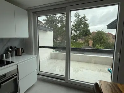 a kitchen with a large window with a view at Beautiful house &parking space in Leuven