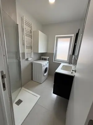 a small bathroom with a washing machine and a sink at Beautiful house &parking space in Leuven