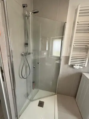 a shower with a glass door in a bathroom at Beautiful house &parking space in Leuven